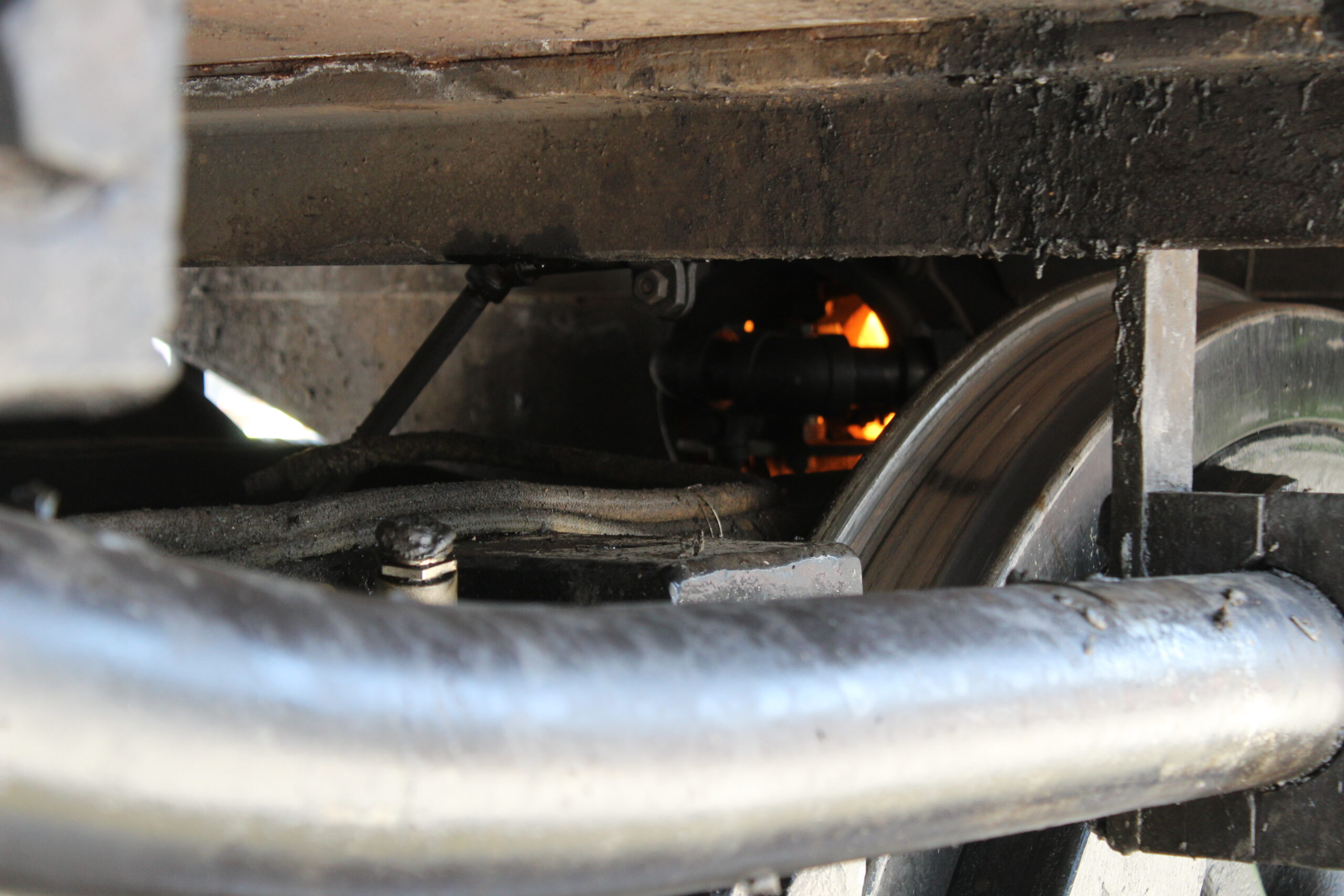 A look under a steam locomotive showing fire in firebox.