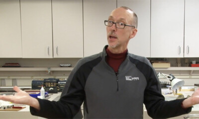 Man with gesturing arms in a work shop.