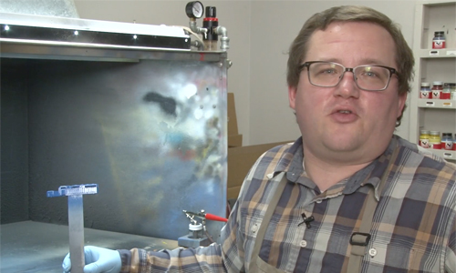 Man holding model in paint room.