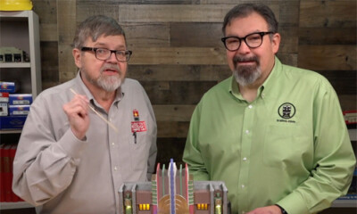 Two men at a table speaking.