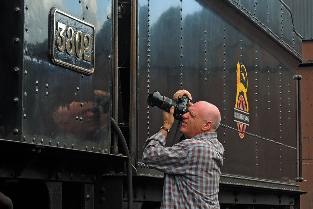 man taking picture of train number