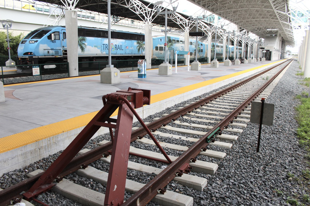 Commuter train at station with unoccupied track in foreground