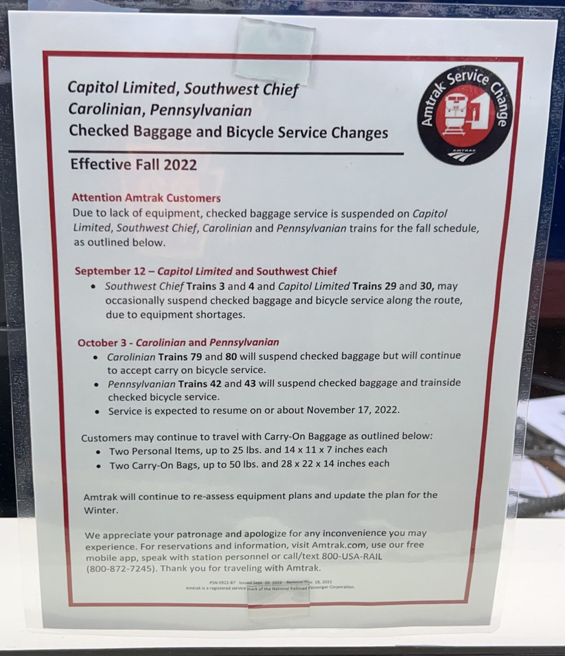 Notice posted in station window with details on cuts in baggage service