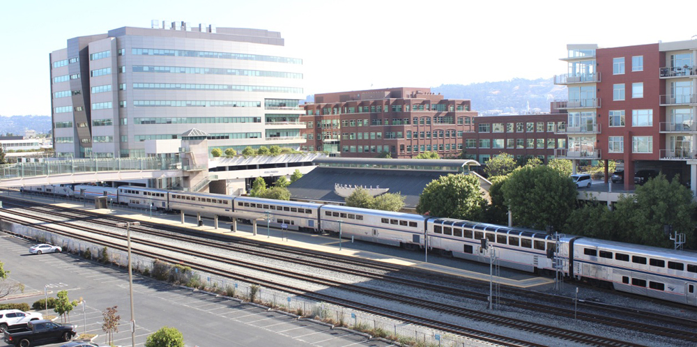 High-angle view of train waiting to leave station with office buildings in the background