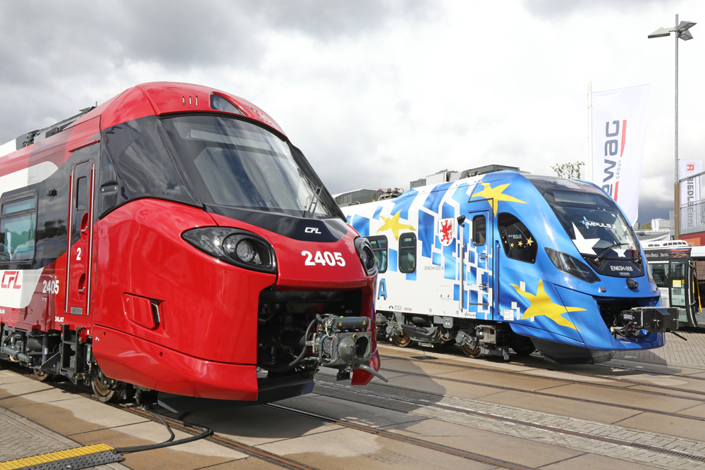 Cab ends of red trainset and blue and white trainset on adjacent display tracks