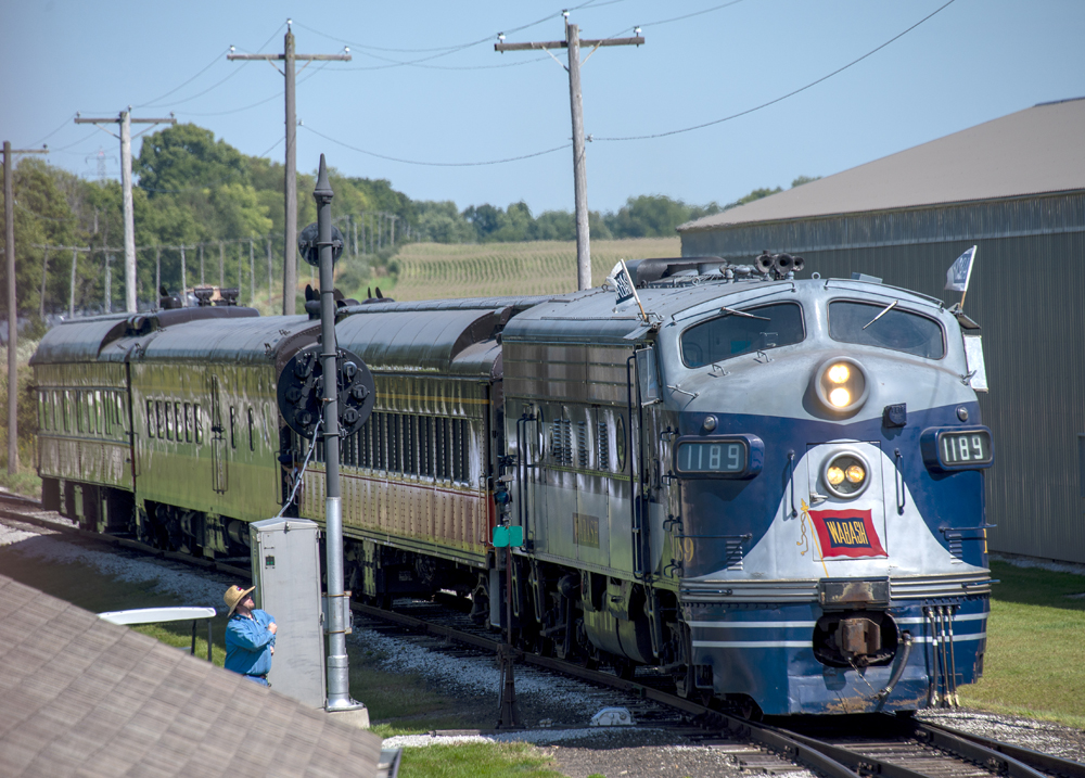 Blue, white, and gray streamlined diesel with passenger train
