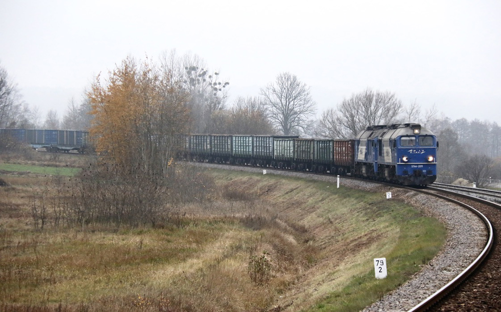 Blue and white boxcab-type diesels bring freight train around a curve
