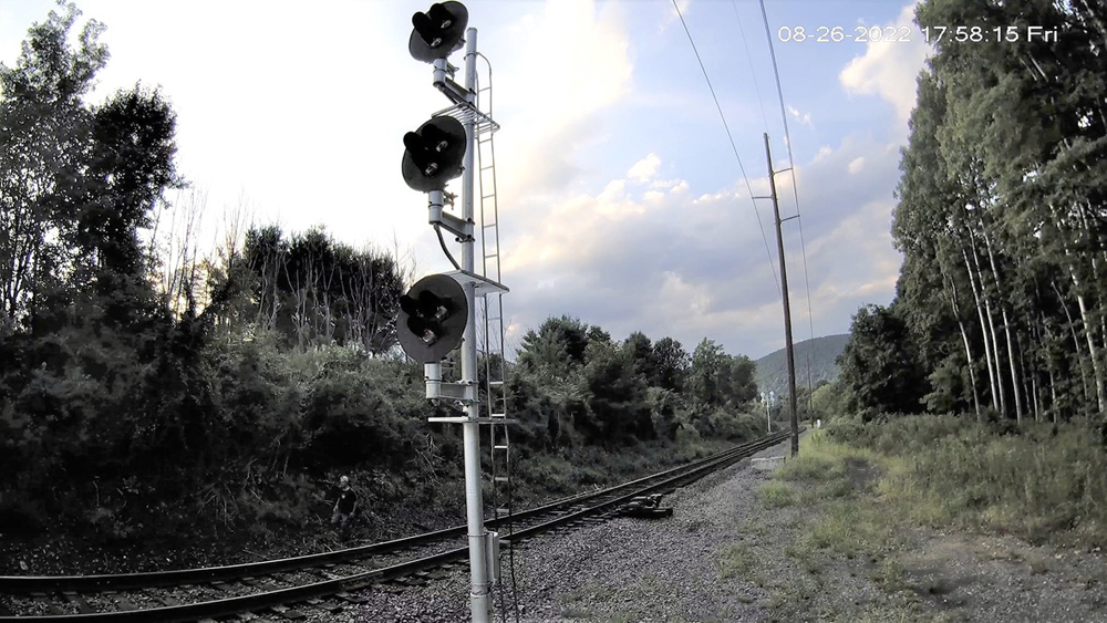 Security camera footage of railroad right-of-way showing man walking along tracks