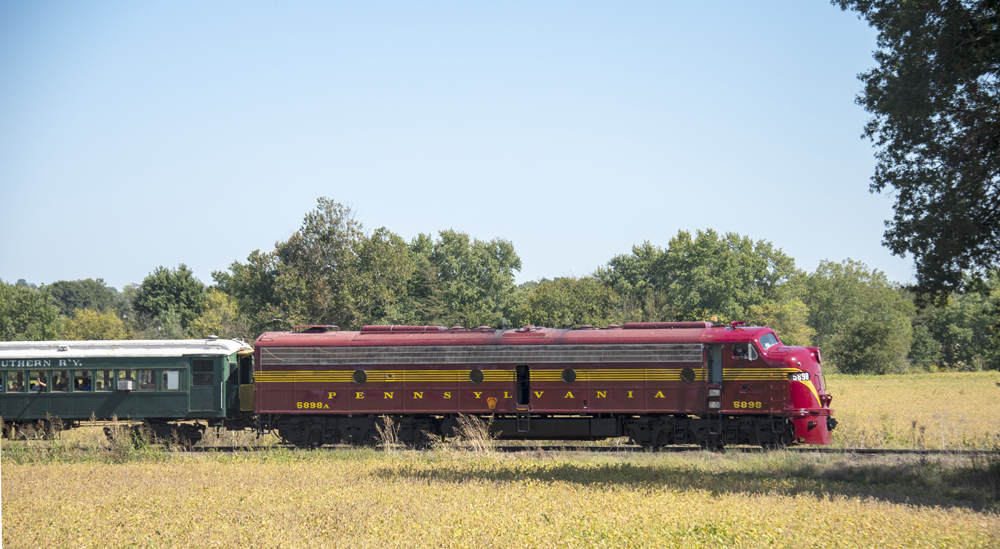 Side view of maroon streamlined diesel locomotive with gold stripes