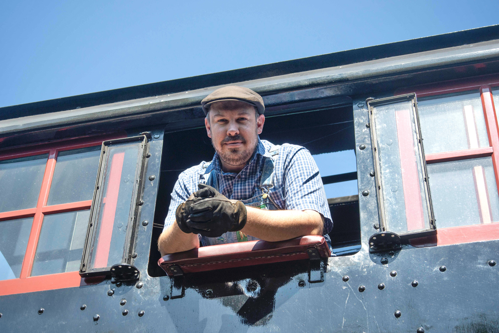 Man leaning out of cab of steam engine