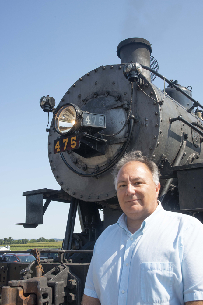 Man standing in front of steam locomotive