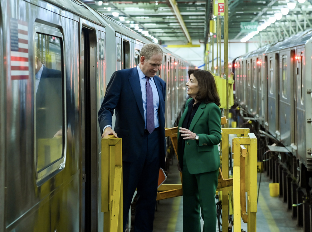 Man and woman talking on platform between subway trains