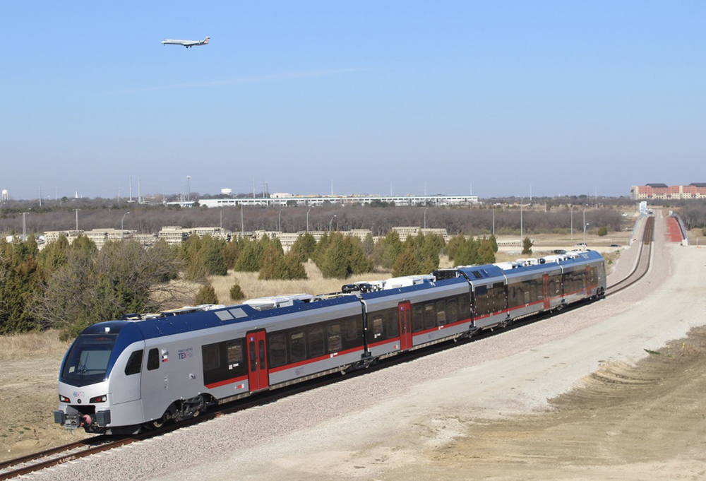 Diesel multiple-unit trainset with airplane overhead