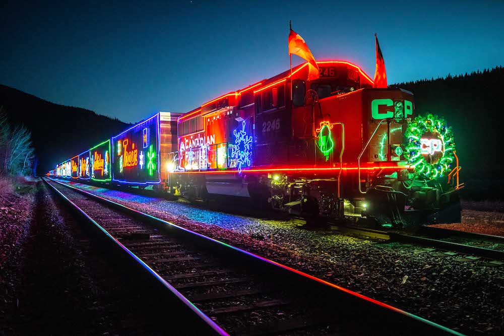 Locomotive and railroad cars decorated with holiday lights