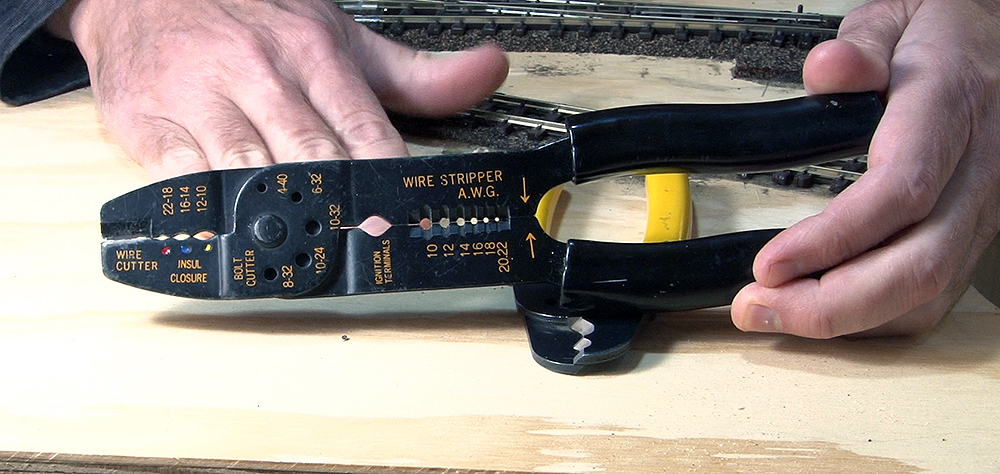 A wire stripper with multiple features, all marked on the tool with orange lettering