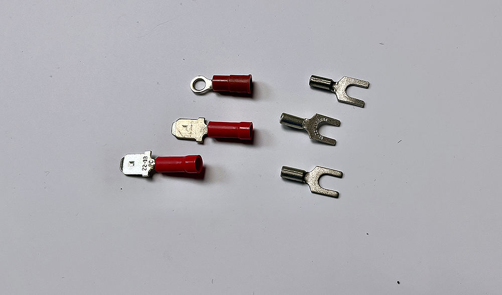 Assorted small metal wire connectors with red colored plastic sleeves