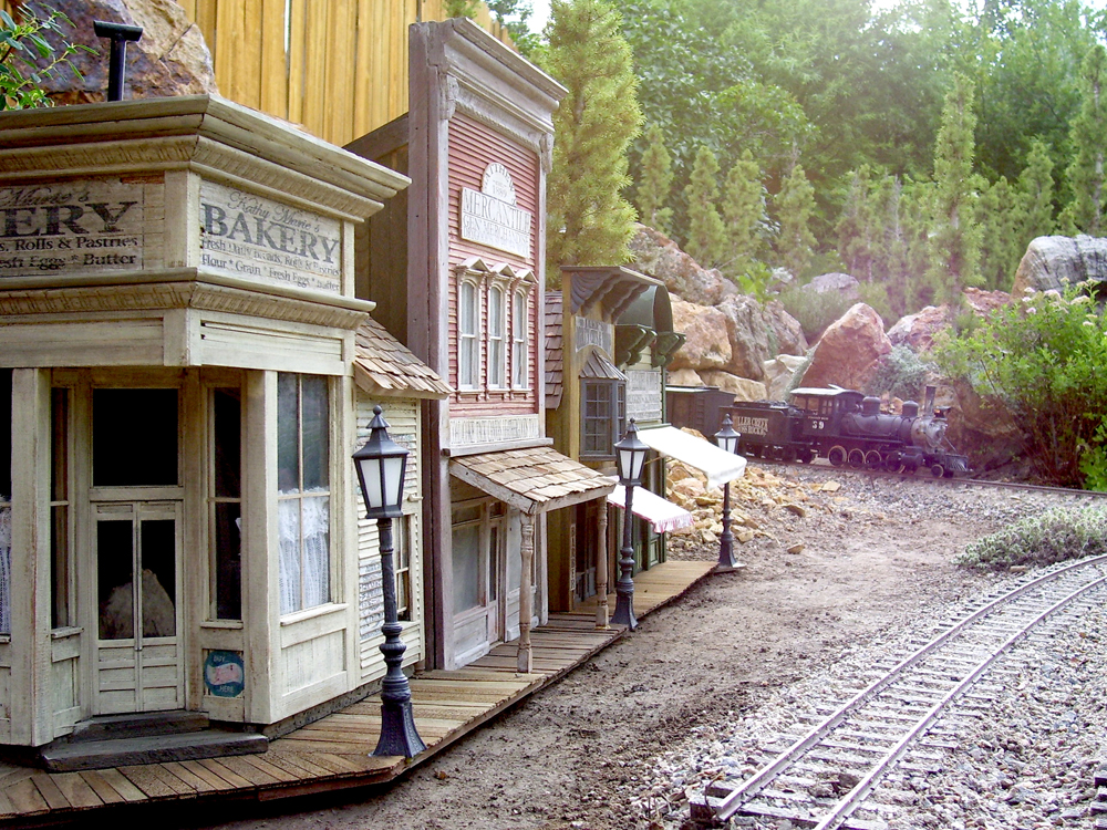 close up of model buildings with steam train in the distance