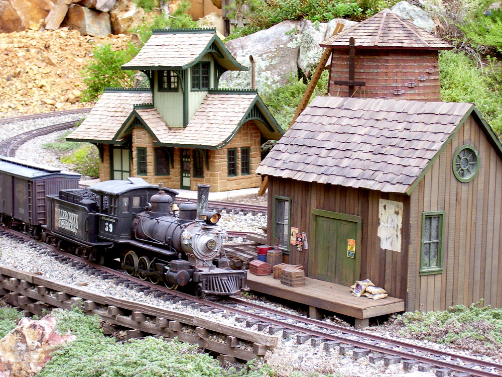 Freelance Colorado narrow-gauge branch line: model steam train approaches buildings