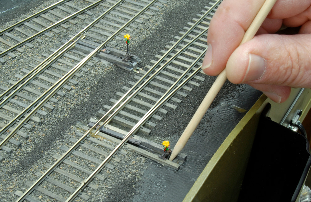 A skewer is used to move a slide switch disguised as a switch stand to control a turnout