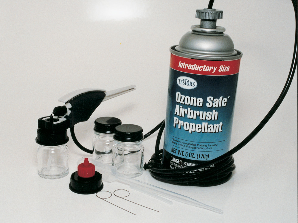 Canned airbrush propellant, an airbrush, air hose, and accessories on a white background