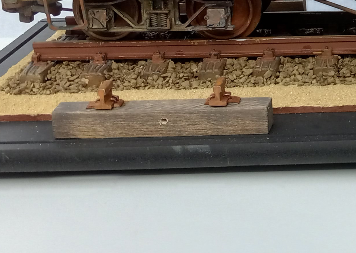 Side view of single railroad tie with pieces of rail mounted on top