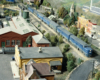 A passenger train passes through a town and industries on an HO scale model railroad