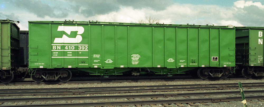 Photo of green freight car parked in rail yard