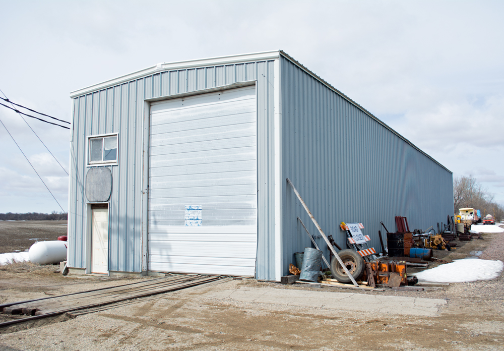 Photo of metal single-track enginehouse with supplies stored along right side