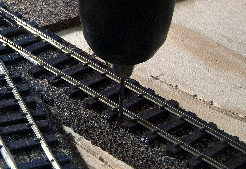 A drill is used to make a hole for the wire.