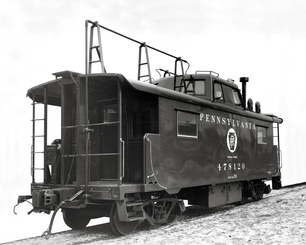 Black-and-white photo of steel caboose with rooftop antenna