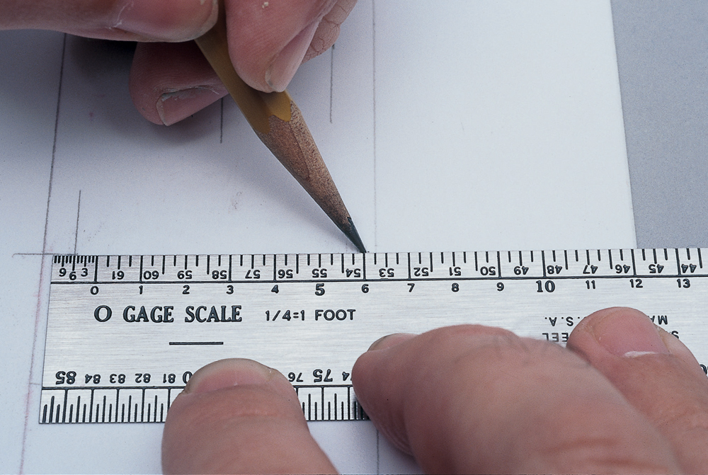hands with pencil using scale rule