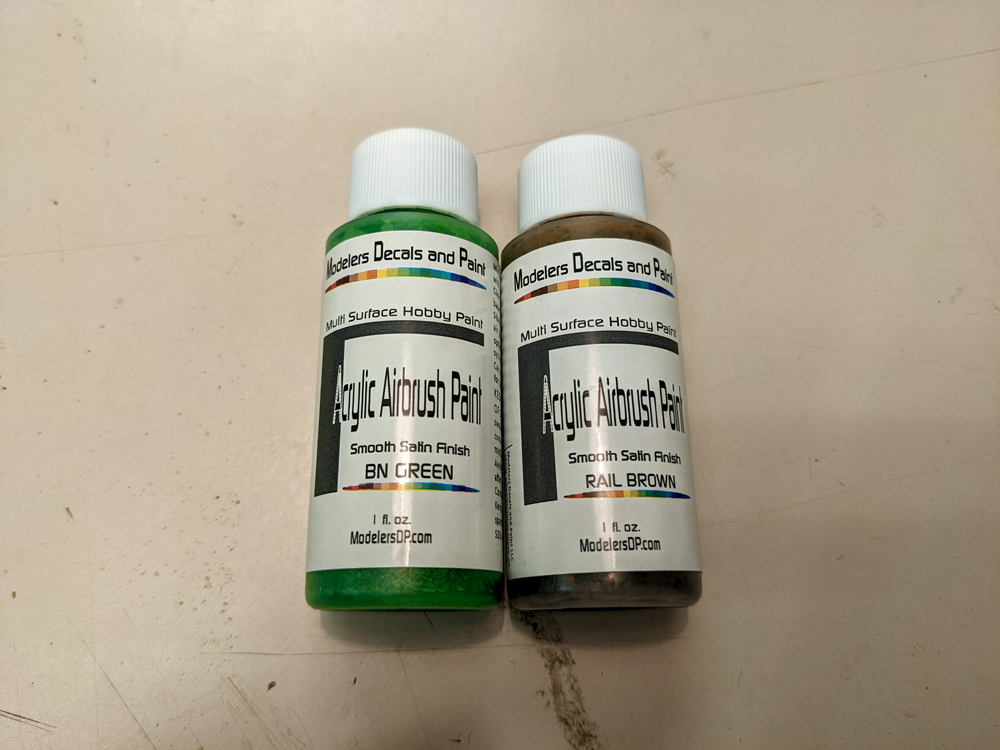 Two bottles of acrylic airbrush paint, one “BN Green” and the other “rail brown”
