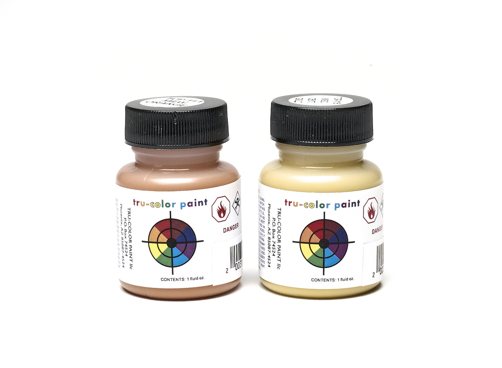 Two bottles of paint, one orange, the other yellow, in front of a white background