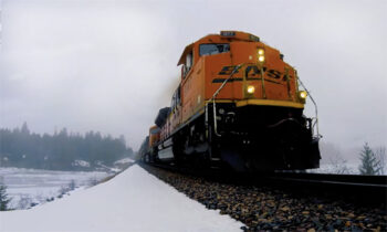 Orange locomotive in a snowy landscape.
