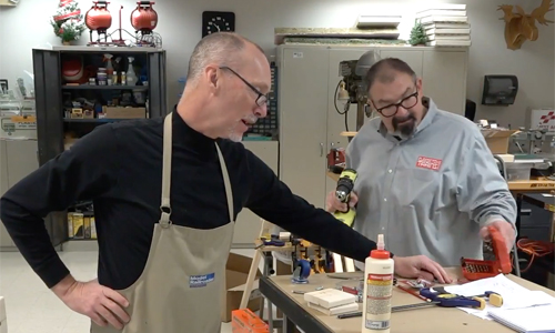 Two men in a workshop talking.