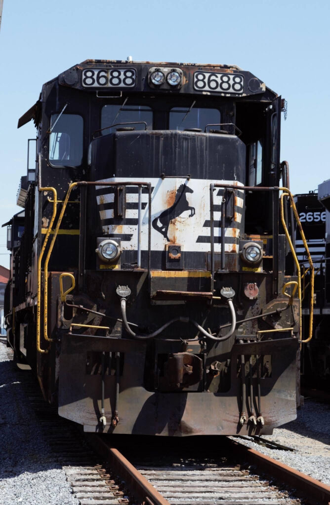 A black painted locomotive in a rail yard.