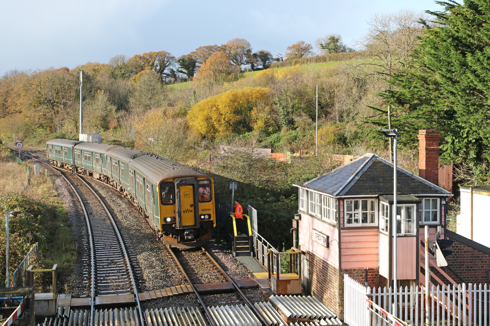 British train stops next to worker at tower