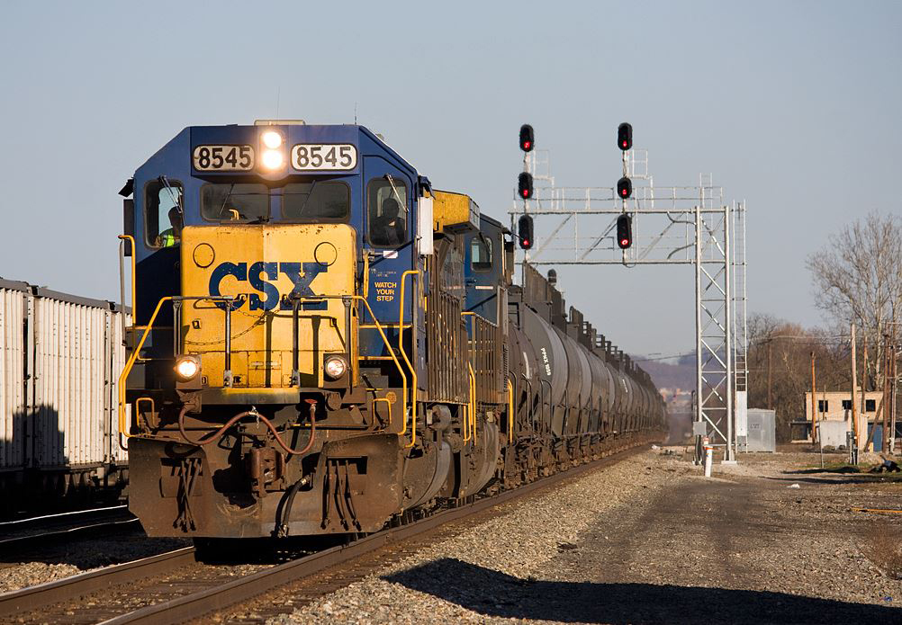 Blue and yellow locomotives with a string of tank cars