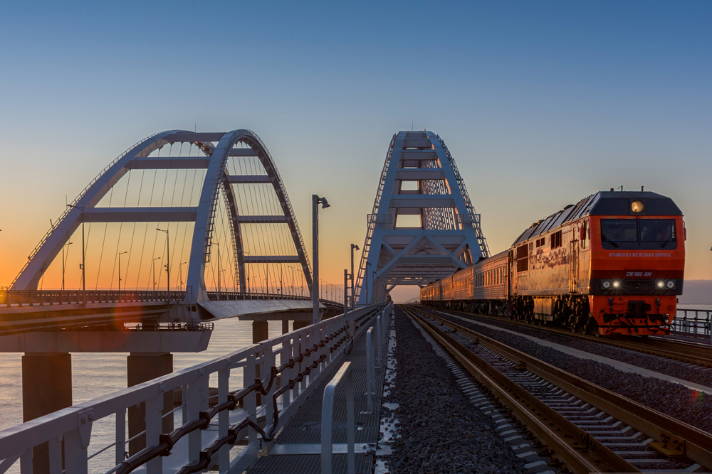 Train at arches on bridge in golden hour