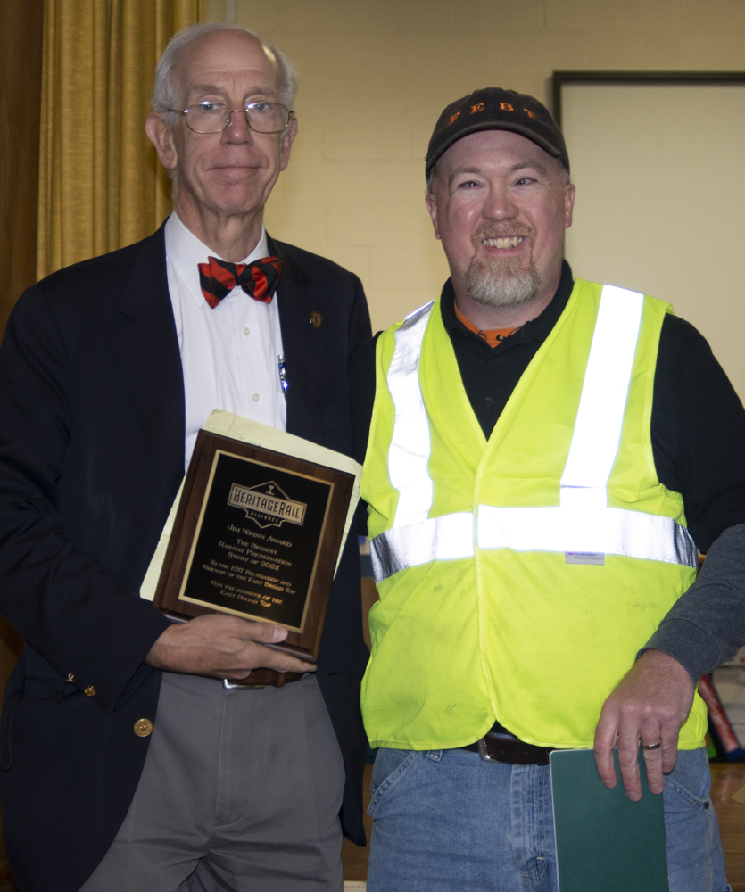 Two men displaying plaque