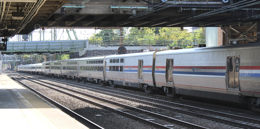 Long passenger train moves away from photographer's location