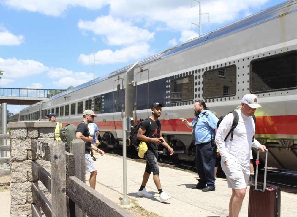 Passengers board train with silver and red cars