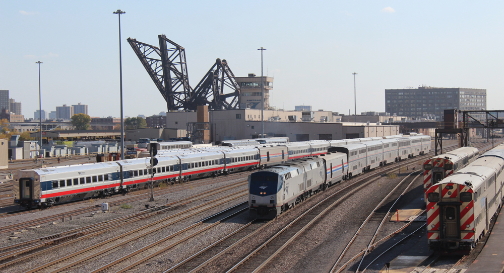 Passenger train passing additional passenger cars in yard