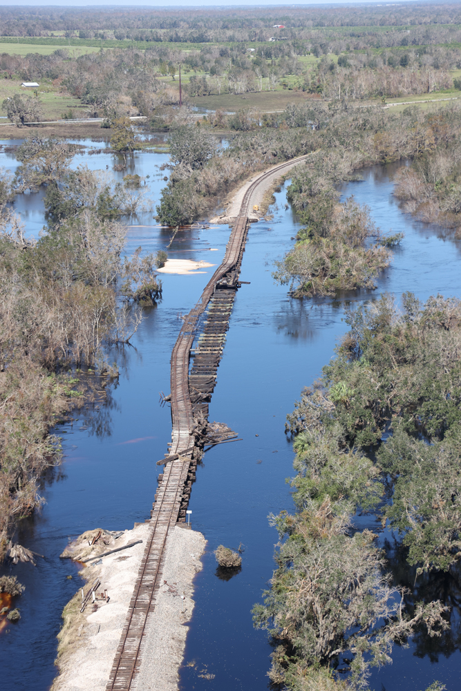 Section of flooded railroad track with bridge knocked off supports