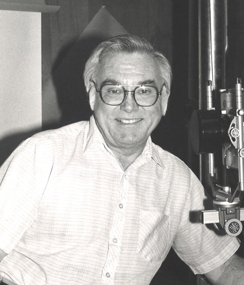 Man next to unidentified piece of equipment, possibly in photo darkroom