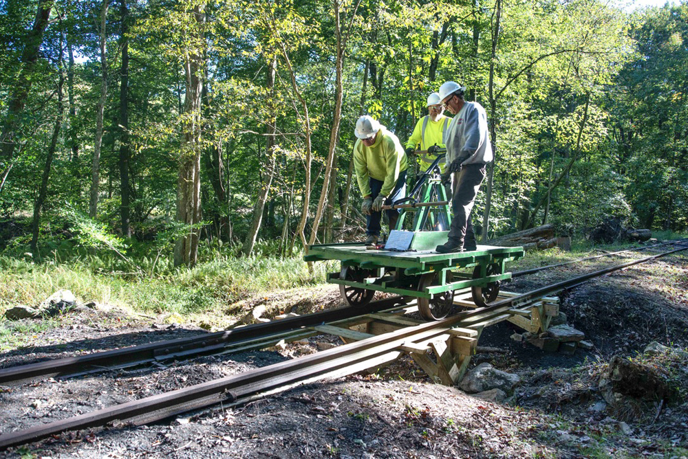 Three men on handcar crossing temporary bridge