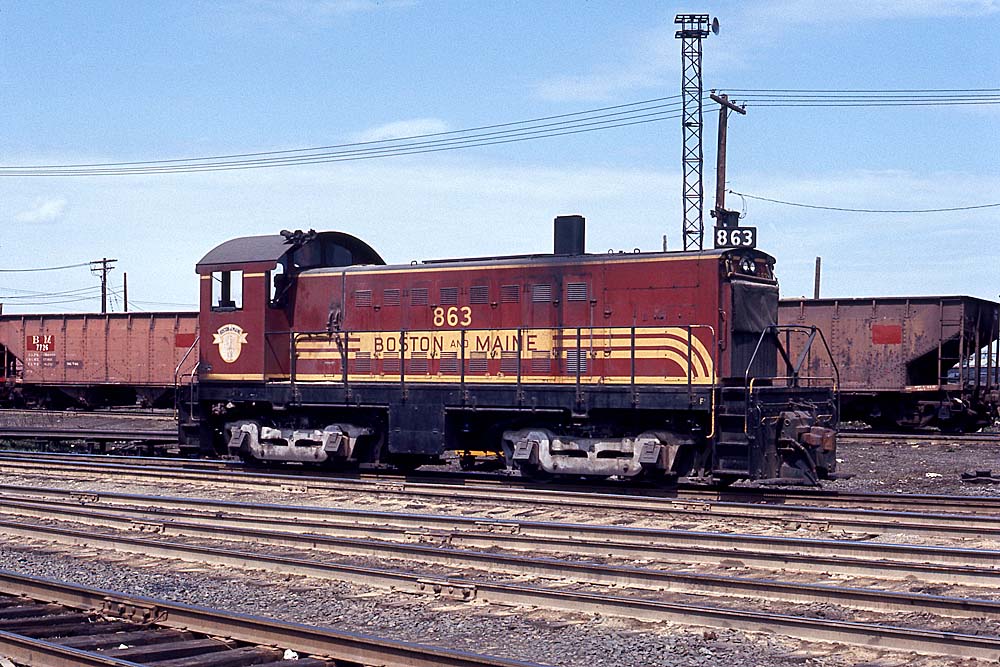 End cab Alco S5 locomotive in train yard in front of light tower