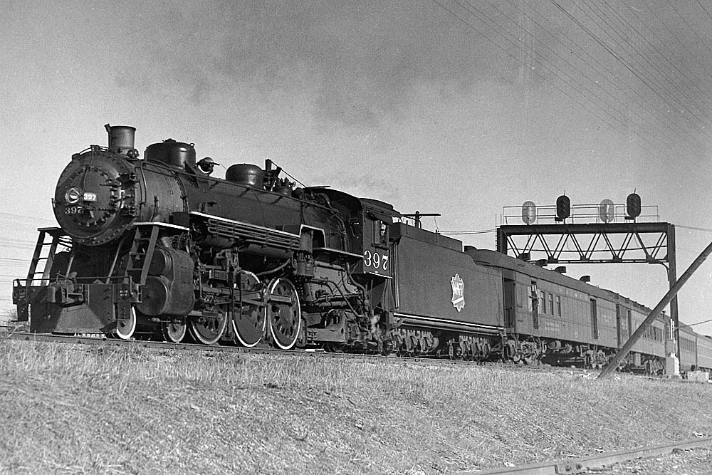 Missouri-Kansas-Texas Railroad steam locomotive with passenger train under signal bridge