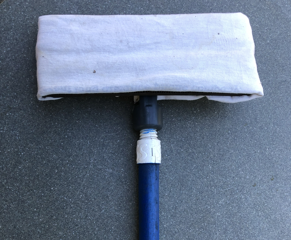 track cleaning pole with pad attached on end