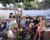 Two adults and four children pose near a garden railway